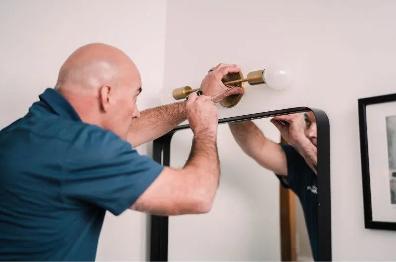 Handyman installs mirror