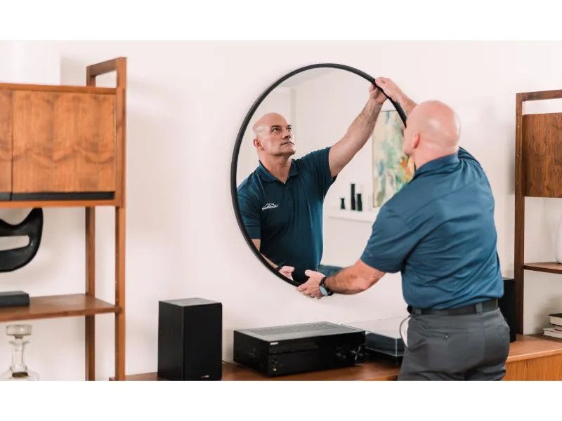 Handyman installs mirror